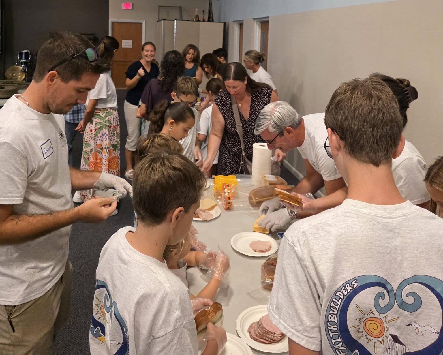 youth group packing sandwiches with the help of their parents